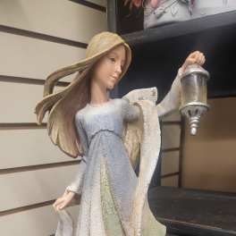 Decorative angel figurine holding a lantern with a printed quote on the base