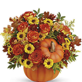 Pumpkin-shaped container filled with orange roses and yellow daisies