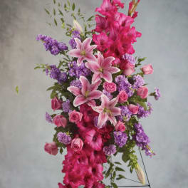 Tall arrangement of pink lilies, roses, and purple flowers