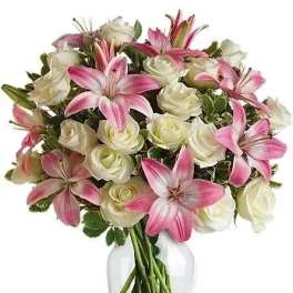 Pink lilies and white roses in a clear glass vase