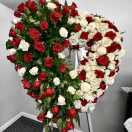 Heart-shaped standing spray of red and white roses on an easel