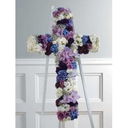 Floral cross-shaped standing arrangement in purple, blue, and white flowers