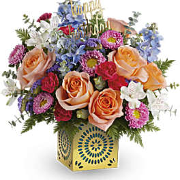 Mixed bouquet with roses, daisies, and a birthday topper in a gold vase