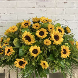 Large sunflower arrangement with greenery on a wooden table