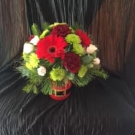 Red gerbera daisies and green chrysanthemums in a small vase