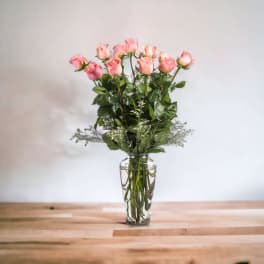 Pink roses arranged in a clear glass vase