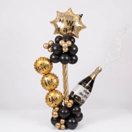 Gold and black New Year balloon arrangement with star and champagne bottle balloons