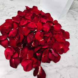 Pile of red rose petals on a marble surface