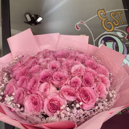 Large bouquet of pink roses wrapped in pink paper
