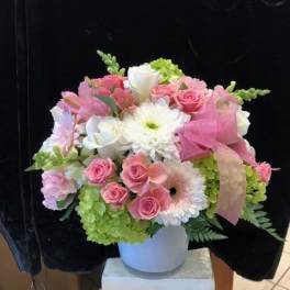 Pink and white mixed flower arrangement in a white vase