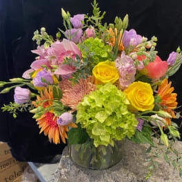Mixed bouquet in a glass vase with yellow roses and pink lilies