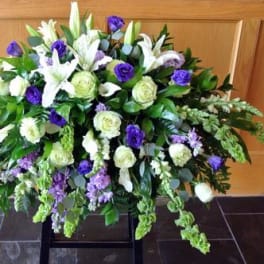 Large white and purple floral spray with cascading greenery