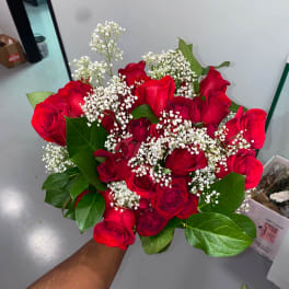 Handheld bouquet of red roses with white baby's breath