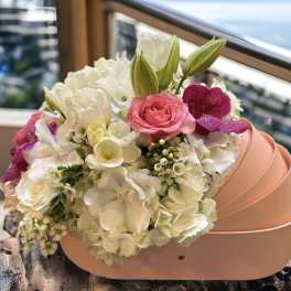 Pink and white bouquet in a peach hatbox with lilies and roses