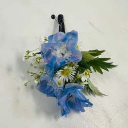Blue and white floral boutonniere with a black pin