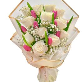 Bouquet of white roses and pink tulips wrapped in cream paper