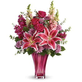 Pink lilies and roses in a tall magenta vase