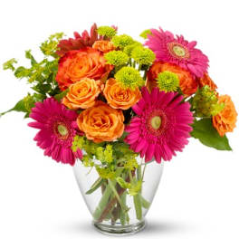 Bouquet of orange roses and pink gerbera daisies in a clear glass vase