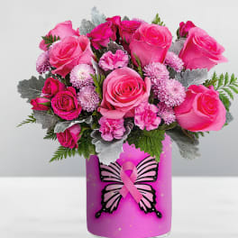 Pink roses and small pink flowers in a decorated vase with a ribbon graphic