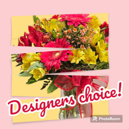 Bouquet of pink and yellow flowers in a glass vase with a red ribbon