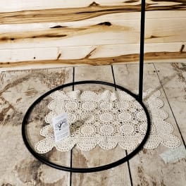 Black metal hanging stand with a circular base and hook top