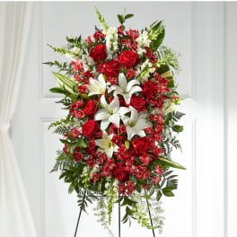 Standing floral spray with red roses, white lilies, and red filler flowers