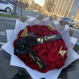 Bouquet of red roses wrapped in black and white paper with a "My Queen" ribbon