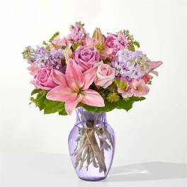 Pink and lavender bouquet in a purple glass vase