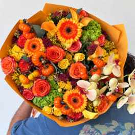 Bouquet of orange and yellow flowers with small pumpkins