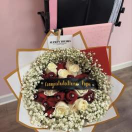Red and white rose bouquet with baby's breath and a congratulatory ribbon