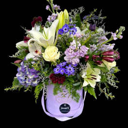 Lavender hatbox arrangement with lilies, roses, and purple daisies