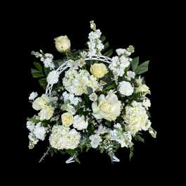 White floral arrangement with roses and hydrangeas in a white stand