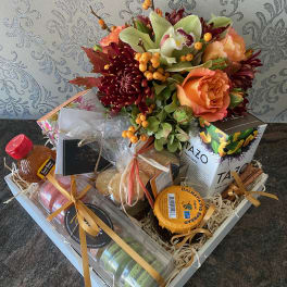 Gift basket with flowers, tea, honey, and packaged treats