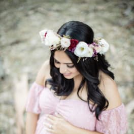 Pregnant woman in a pink dress wearing a floral crown