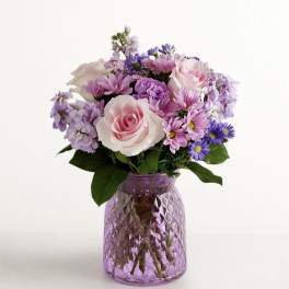 Pink and lavender mixed bouquet in a purple glass vase