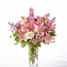 Pink lilies and roses in a clear glass vase