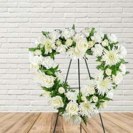 White floral heart wreath on a black easel