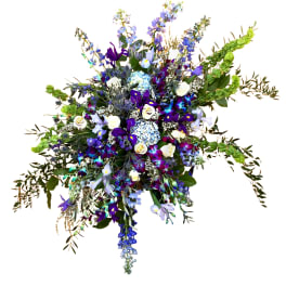 Large spray of blue, purple, and white flowers with trailing greenery