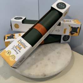 Stacked plant care mats in retail packaging on a round marble stand