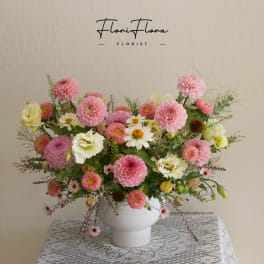 Pink and white mixed flower arrangement in a white vase