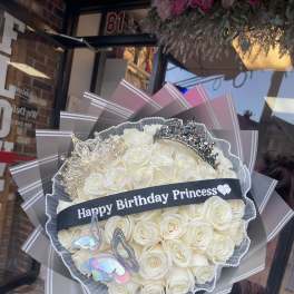 Bouquet of white roses with crowns and a birthday ribbon