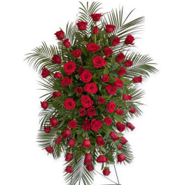 Standing spray of red roses with palm fronds on a wire easel