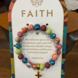 Beaded bracelet with a gold cross charm on a faith card