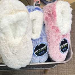 Plush slipper socks in a metal basket, shown in gray, white, blue, and pink.