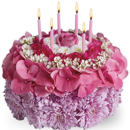 Pink floral cake with lit candles