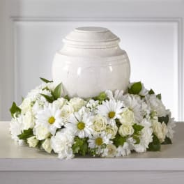White floral wreath around a white urn