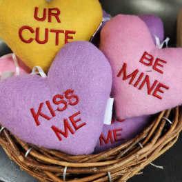 Heart-shaped plush gifts in a wicker basket with embroidered messages