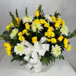 Yellow roses and white chrysanthemums arranged with a white ribbon bow