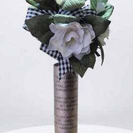 White rose memorial arrangement with a plaid ribbon on a stand