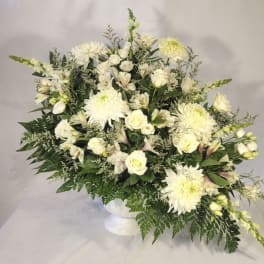 White floral arrangement in a white pedestal vase